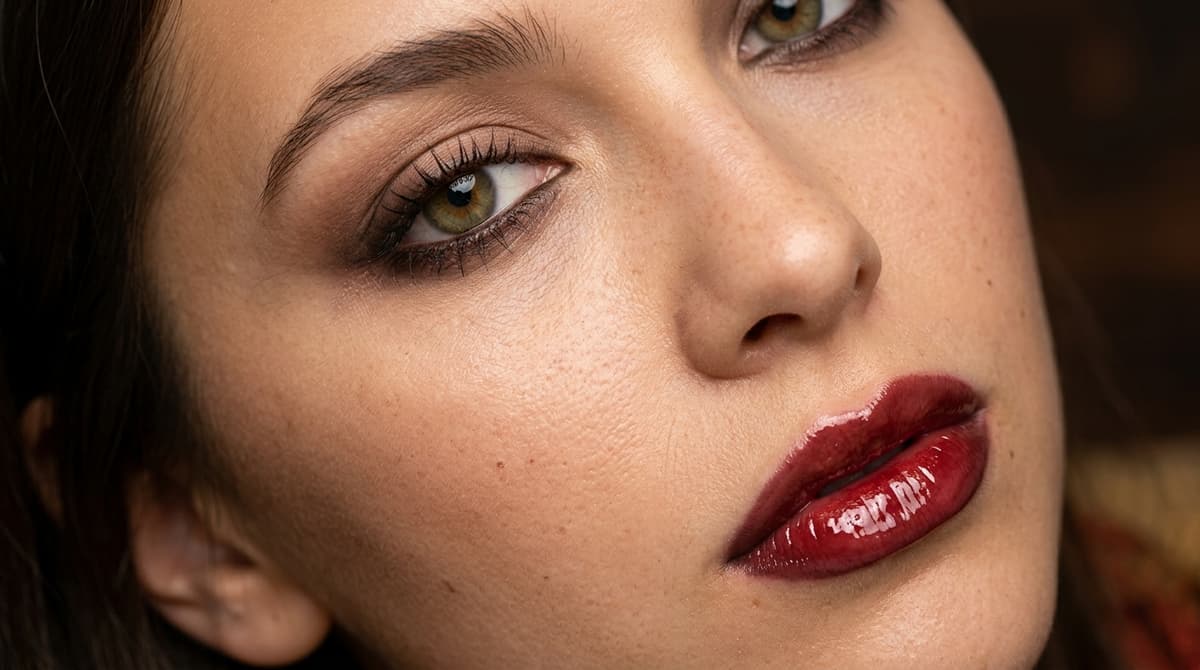 Macro shot of autumn espresso eyeshadow and high-shine cherry cola glazed lips