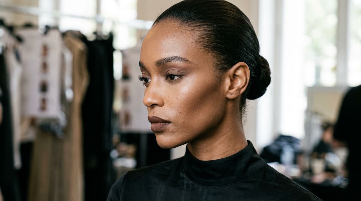 Paris Fashion Week backstage model showcasing monochromatic espresso beauty with sculpted cocoa cheekbones and sleek hair